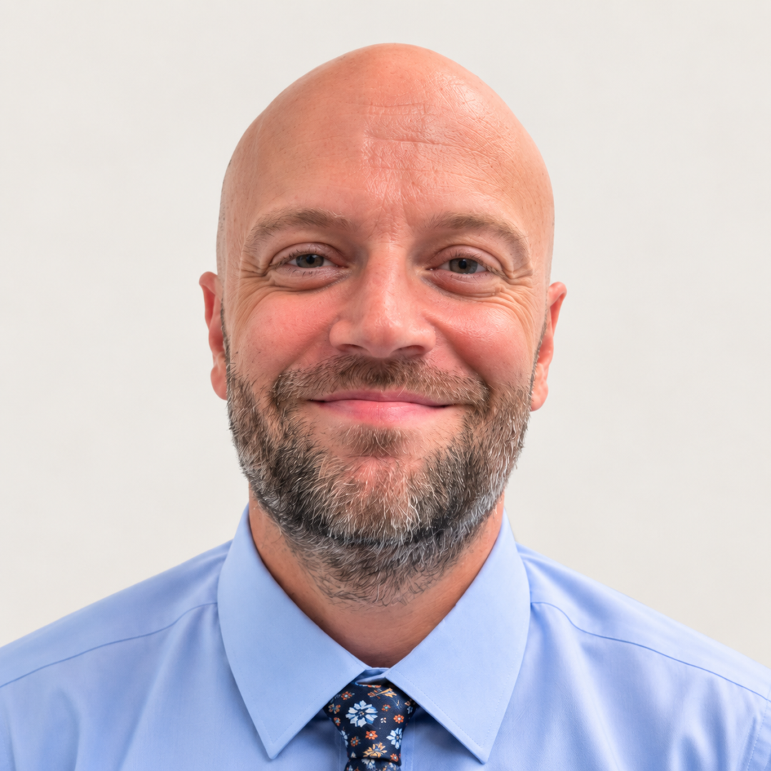 Warm Professional Headshot of a Bearded Bald Man